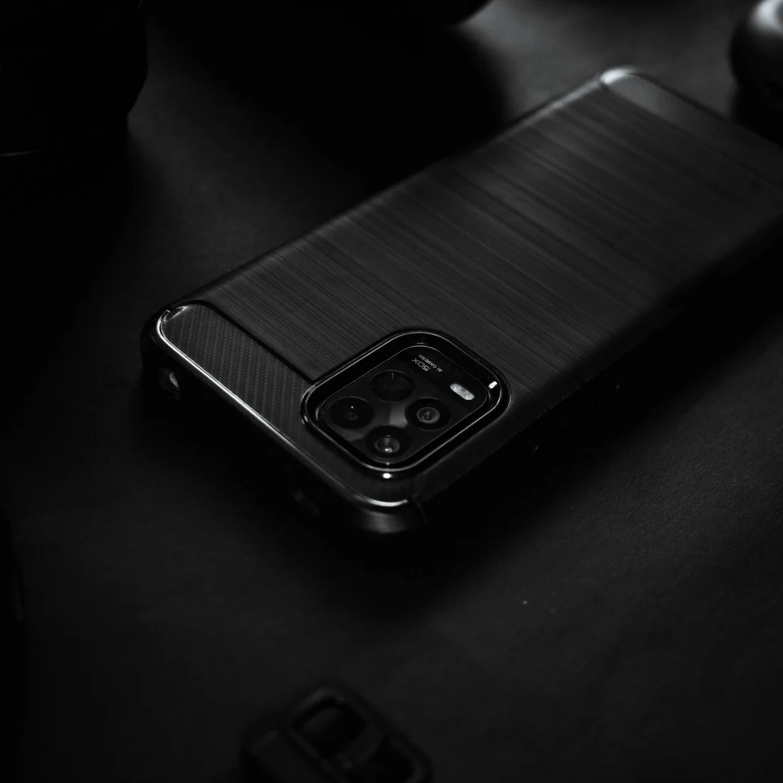 Smartphone preto em close sobre superfície escura